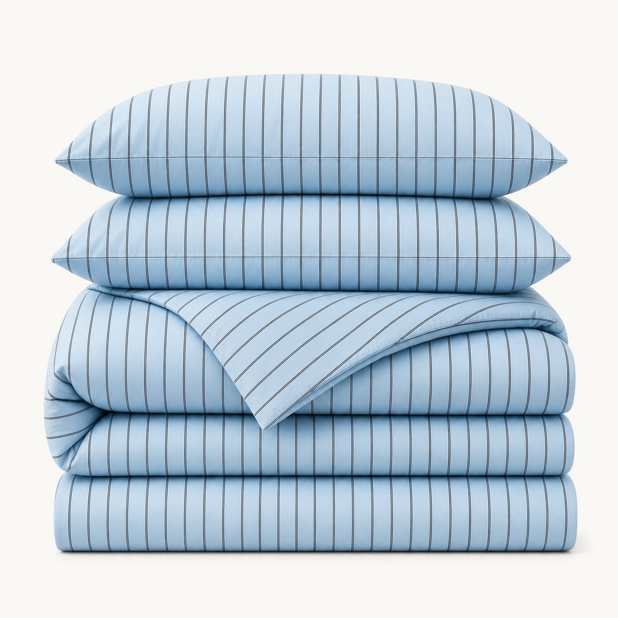 Stacked Blue Stripe cotton sateen bedding set on a warm off-white background